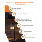 Black shepherd hook garden light with lantern-style glass enclosure and solar panel on top in 2PK set
