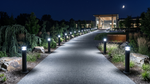 Black commercial led bollard light with cone reflector illuminates nighttime pathway with bright white led fixtures