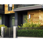 Modern house exterior with wooden facade, glass windows, and greenery.