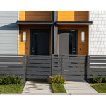 Modern house exterior with a gray front door and black fence.