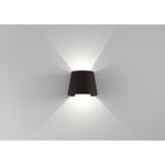 Bronze wall-mounted light on a white wall