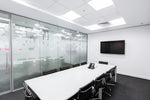 White rectangular conference table with black chairs illuminated by 2 x 2 foot back lit led flat panel 5000 lumens