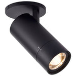 A modern matte black track spotlight with a circular ceiling mount, shown at an angle with its light turned on, against a solid white background.