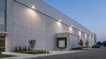 Modern light gray concrete warehouse illuminated by led traditional wall pack with adjustable beam angle and integrated photocell