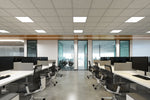 Modern black ergonomic office chairs with silver metal bases beside a 2 x 4 foot back lit led flat panel light