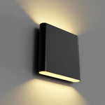 A modern black rectangular wall sconce light fixture mounted on a gray wall, casting warm yellow light upwards and downwards.