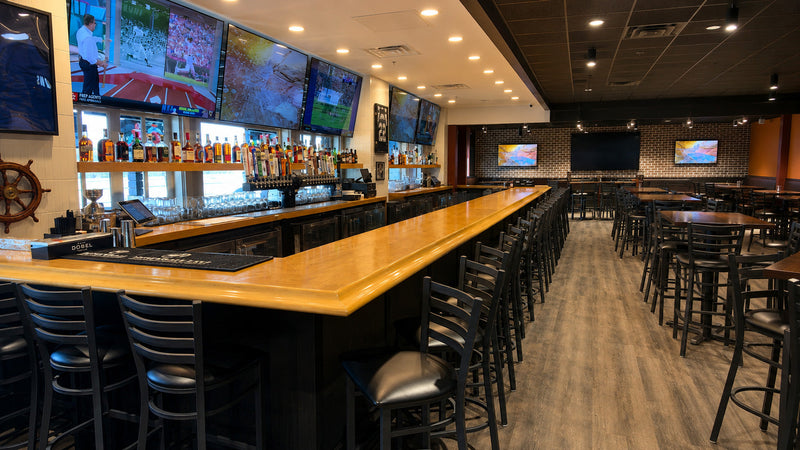 Recessed LED downlights above a long bar with screens in a sports bar and grill