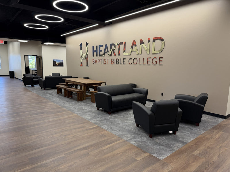 Illuminated 48-inch LED round pendant rings with black housings above a college student commons seating area