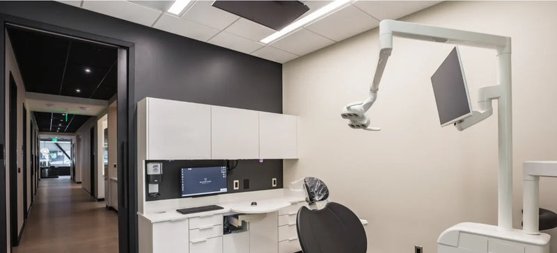 Linear LED fixtures set flush in a T-grid ceiling in a dental operatory at Willow Glen Dental