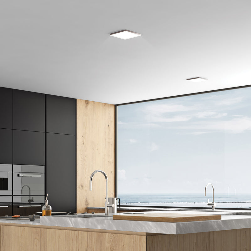 Modern kitchen with black cabinets, marble countertop, and large window.