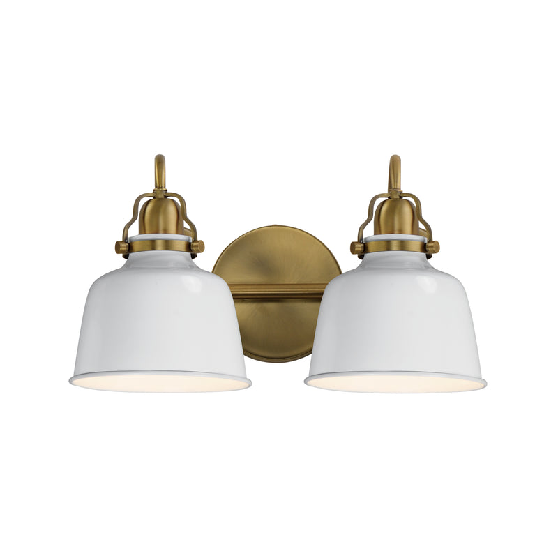 A two-light wall sconce with white bell-shaped glass shades and an antique brass backplate and hardware, shown against a plain white background.