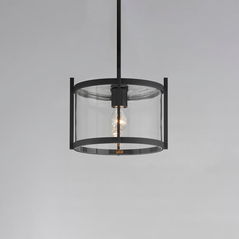 Black pendant light with clear glass shade on a gray background