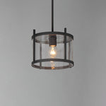 Pendant light with clear glass shade and black metal frame on a gray background