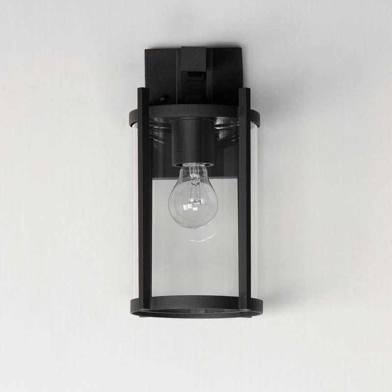 Black wall-mounted light fixture with a clear glass cover on a white background