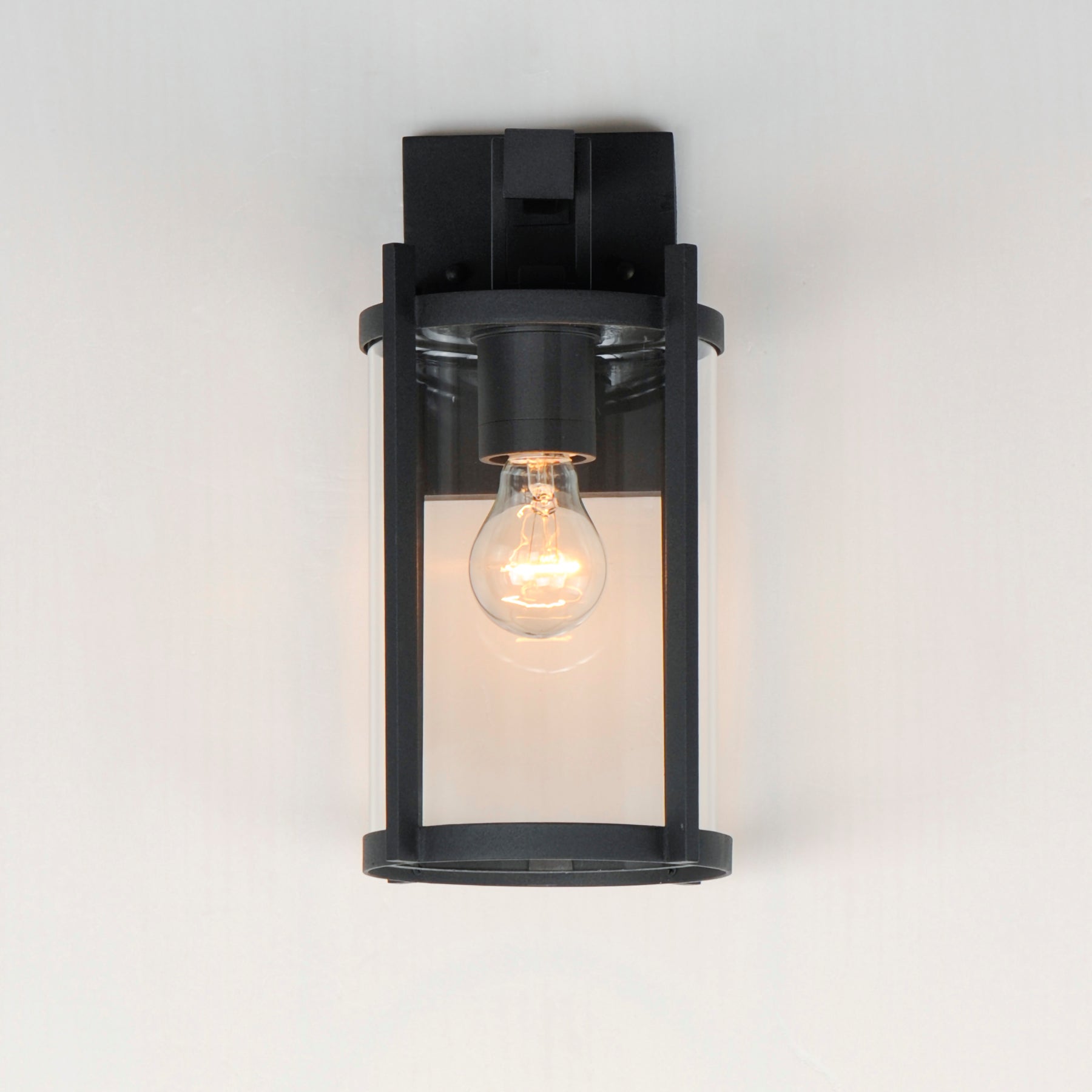 Black outdoor wall light fixture with a clear glass cover on a white background