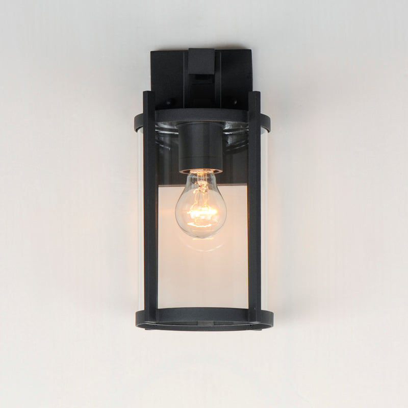 Black outdoor wall light fixture with a clear glass cover on a white background