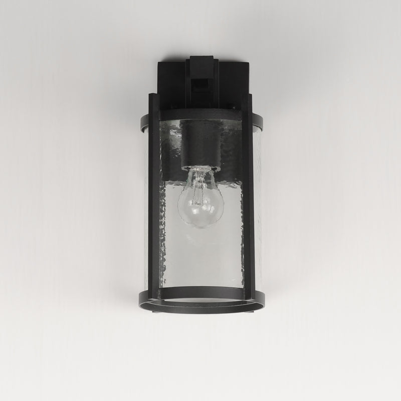 Black outdoor wall light fixture with clear glass cover on a white background