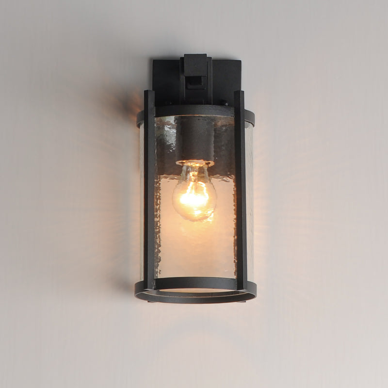 Black outdoor wall light fixture with clear glass cover on a gray background
