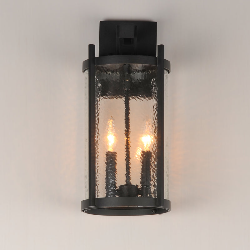 Black outdoor wall light fixture with glass cover on a neutral background