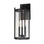 Black outdoor wall light fixture with clear glass on a white background
