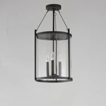 Black pendant light fixture with clear glass shade on a gray background
