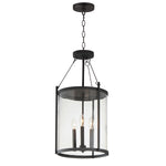 Black pendant light fixture with clear glass shade on a white background