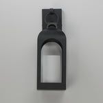 A matte black outdoor wall sconce with a lantern-style frame and a glass panel, shown against a neutral light gray background.
