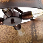 Close-up detail of a rustic bronze metal light fixture with visible screw posts, round central plates, and clear glass bulbs inside a textured brown shade.