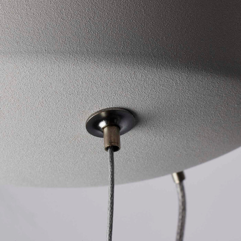 Close-up of a ceiling light fixture with a textured gray shade and visible wiring.