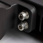 Close-up of two metal screws on a black mechanical component.