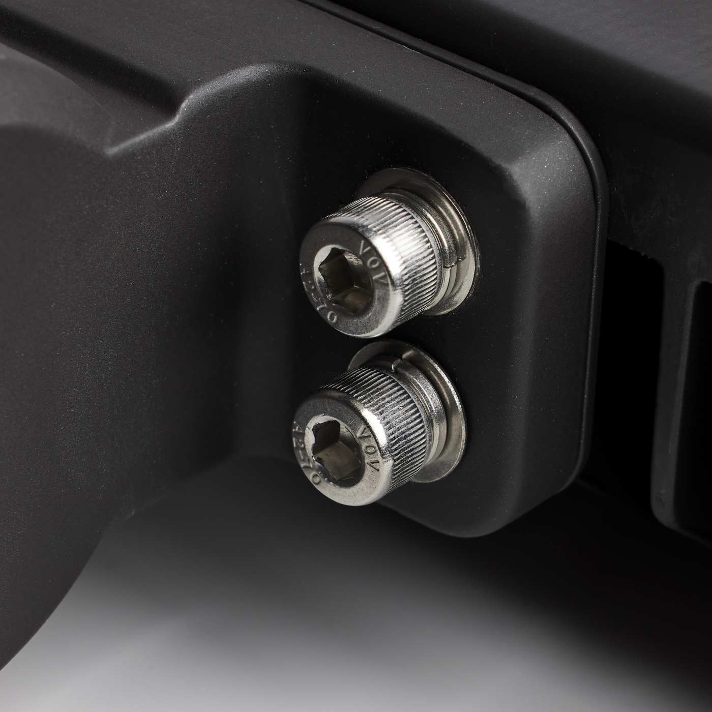 Close-up of two metal screws on a black mechanical component.