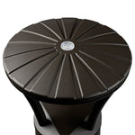 Black circular patio table with textured ribbed top and central silver emblem shown alongside bronze led bollard light with selectable wattage and cct