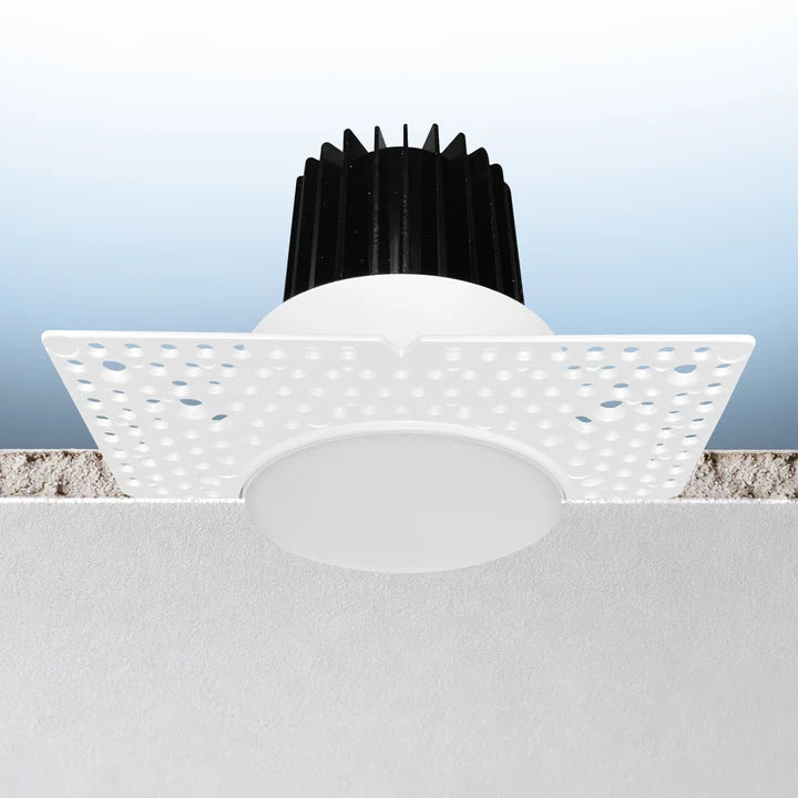 A modern flush-mount LED ceiling light fixture with a white square diffuser, a circular white light dome, and a black ribbed heat sink, shown installed against a textured ceiling.