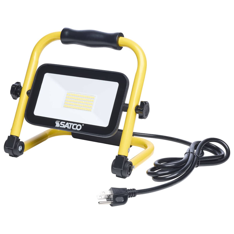 A Satco portable LED work light with a yellow and black handle, shown with its power cord and plug on a white background.