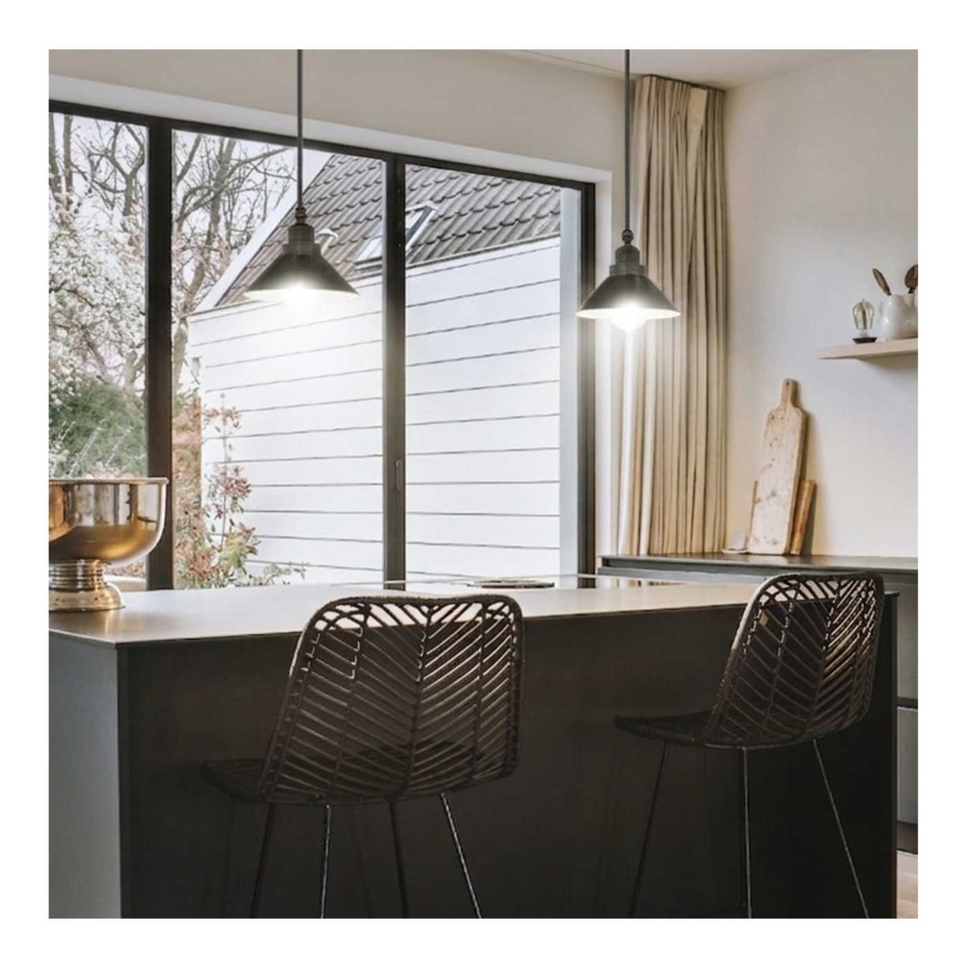 Modern kitchen with a large window, pendant lights, and black chairs.