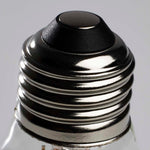 Close-up of a light bulb base with a metallic finish on a gray background