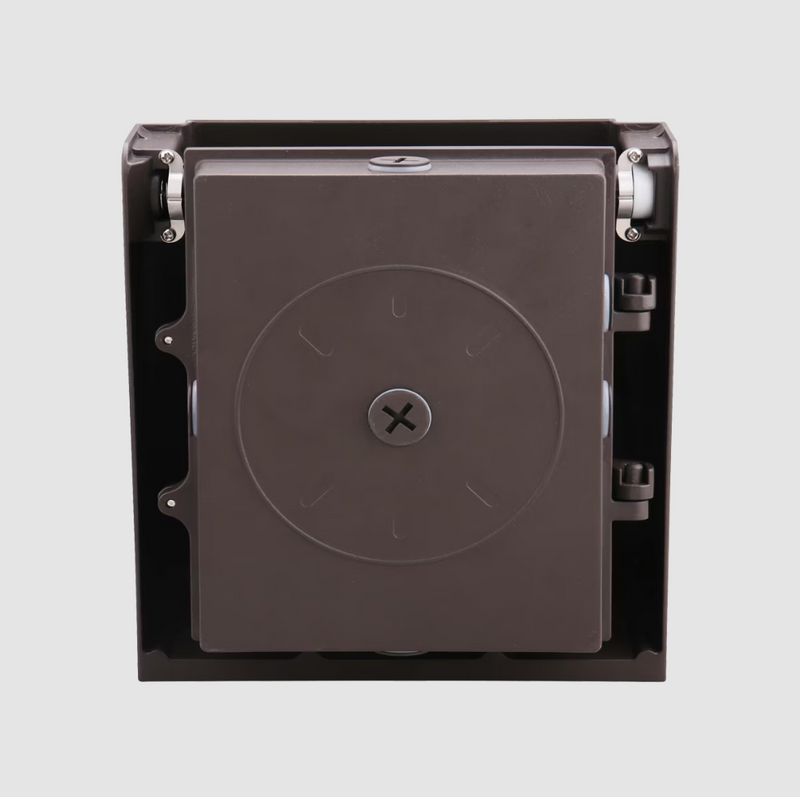 Bronze outdoor wall pack light with a central circular component on a gray background