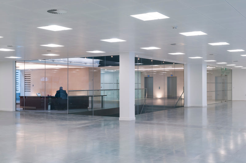 Modern minimalist office space illuminated by 2x2 led troffer center basket with selectable wattage and cct