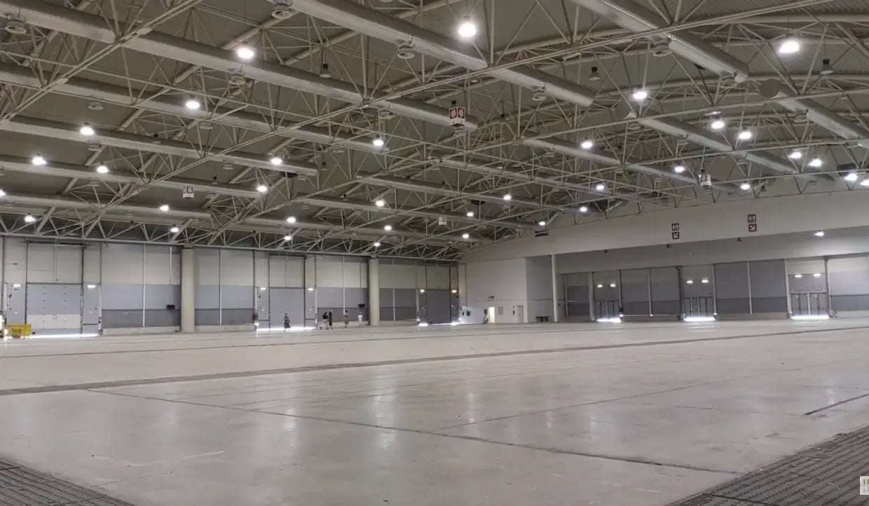 Aries G6 LED UFO high bays installed in a large industrial facility with exposed steel roof trusses and high ceilings