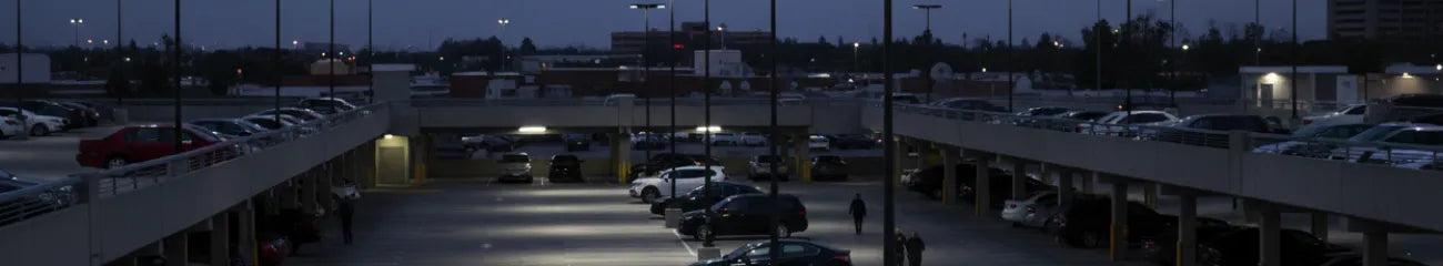 Multi-level outdoor parking structure illuminated by LED pole lights at night.